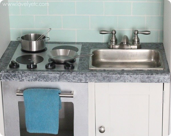 DIY play kitchen from an entertainment center - Lovely Etc.