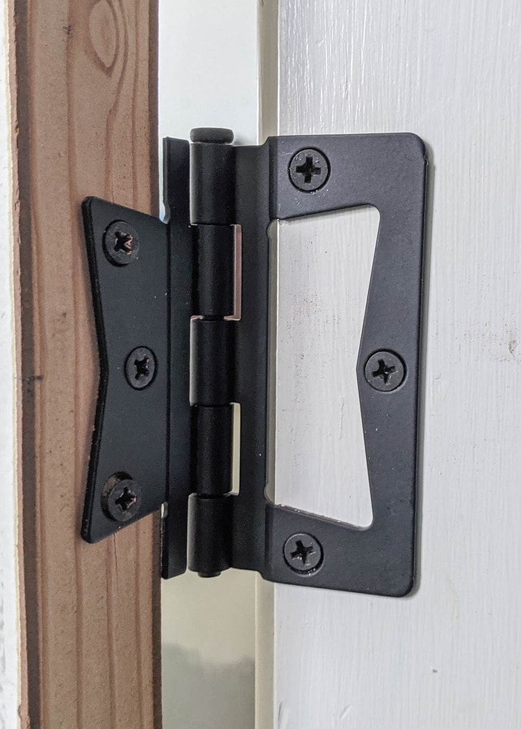 close up of non-mortise hinge attached to door and door frame.