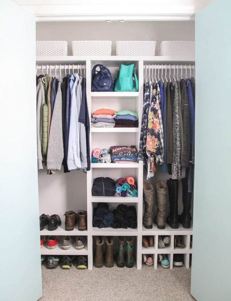 https://www.lovelyetc.com/wp-content/uploads/2021/03/diy-closet-organizer-in-small-closet-filled-with-clothes-and-shoes-735x958.jpg